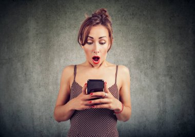 Gri arka plan üzerinde cep telefonu, beklenmeyen metin iletisini için sürpriz kadına hayran