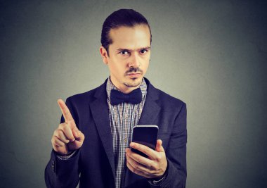 Ciddi genç iş adamı ile parmak ile hiçbir ilgi gösterilen smartphone. 