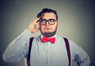 Eksantrik tombul adam fikri üzerine konsantre ve seyir kafasına elini tutarak endişeli. 