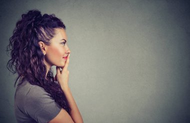 Yan görünümü çok esmer tefekkür dudaklarında dokunmadan ve uzak fikir gri arka plan üzerinde düşünmek seyir. 