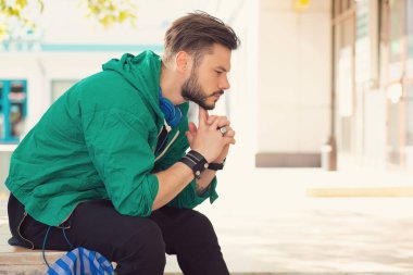 stresli bir üzgün genç adam açık havada oturma portre. Şehir kentsel yaşam tarzı stres 
