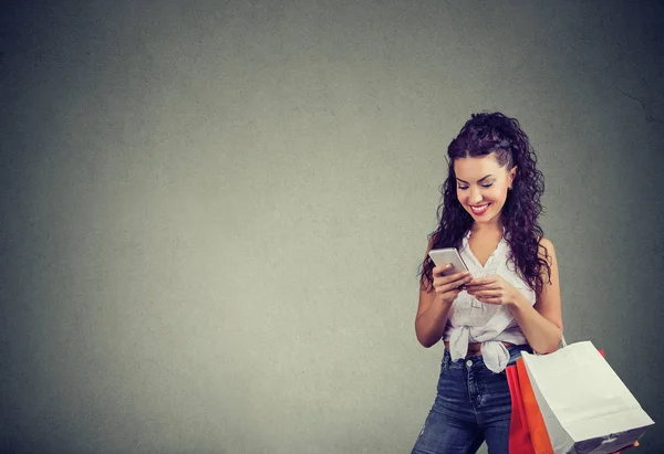 Ενθουσιασμένος Μοντέρνο Κορίτσι Τις Τσάντες Έγγραφα Χρησιμοποιώντας Smartphone Για Ψώνια — Φωτογραφία Αρχείου