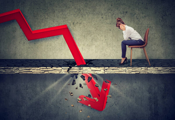 Депрессивная деловая женщина смотрит вниз на падающую красную стрелу, проходящую через бетонный пол. Концепция падения и амортизации
.