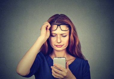 Gözlük dayanabiliyor ve gözleri ile ilgili sorunlar yaşıyorsanız smartphone izlerken genç Kızıl saçlı kız