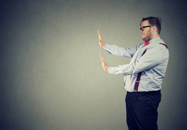 Bir iş adamı resmi kıyafeti eller kendini önünde karşı iterek ve durdurmaya holding yan görünüm
