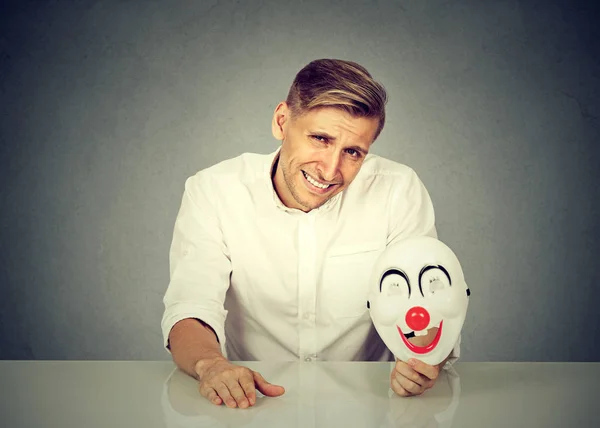 Jonge Knappe Man Zit Aan Tafel Met Nep Masker Handen — Stockfoto