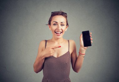 Modern yenilikçi smartphone tutarak ve gülümseme ile işaret içinde şık güzel kadın 
