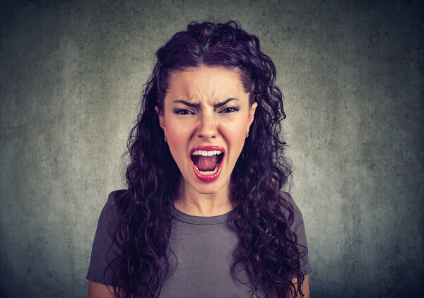 Closeup of young woman screaming at camera