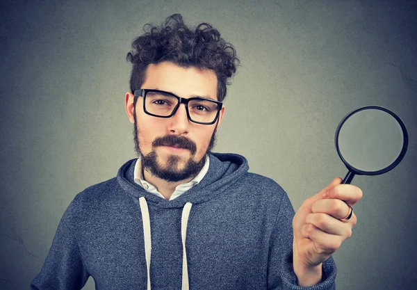 Bearded Scrupulous Man Glasses Holding Magnifying Glass Looking Camera Gray — Stock Photo, Image