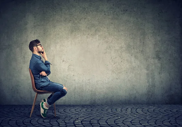 Vista Lateral Homem Consciente Solitário Sentado Cadeira Contemplando Plano Contra — Fotografia de Stock