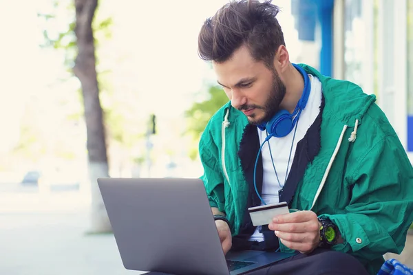Hipster 무릎에 노트북으로 거리에 카드와 온라인 구매를 — 스톡 사진