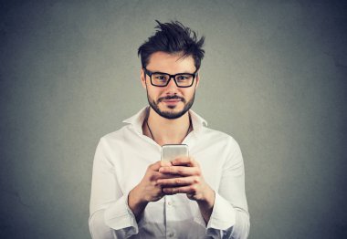 Mutlu sakal hipster adam gözlüklü bir smartphone kullanarak