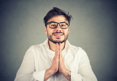 Gözlük ve jest yalvarıyor ve grace için gri arka plan üzerinde soran birlikte elele forması giyen genç sakallı