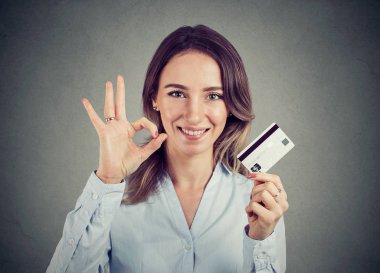 mutlu genç iş kadını ile kredi kartı ok el işareti hareketi vererek 