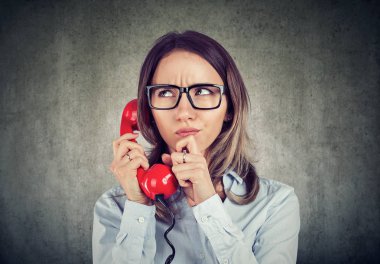 Genç kadın gömlek ve çağrı telefon üzerinde olması ve sorunları ile ilgili karışıklık ile çatık gözlük