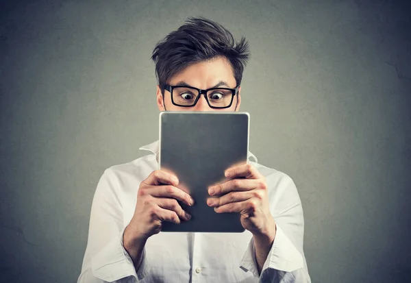 Ung Man Håller Tablett Framför Ansiktet Ser Förvånade Och Chockade — Stockfoto