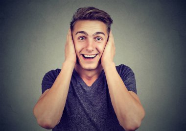 Kulakları kapsayan ve çatışma kaçınarak ve kameraya gay arka plan üzerinde seyir sırasında gülümseyen rahat yakışıklı adam