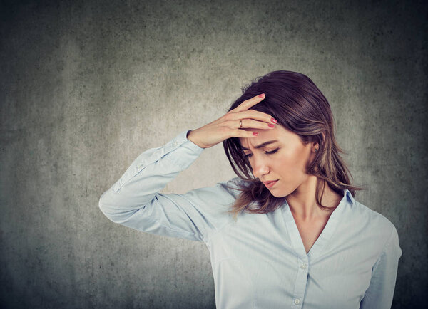 Closeup portrait of a sad young beautiful woman with worried stressed face expression looking down  