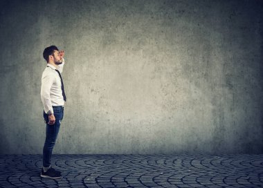 Şık işadamı uzak gelecek planlama ve tahmin gri arka plan üzerinde yapıyor görünümlü yan görünüm