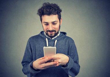 SMS tipik ve gülümseyen bir akıllı telefon kullanan mutlu sakal hipster adam 