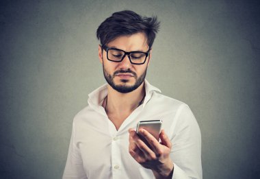 Papatyanın delikanlı smartphone içinde antipati gri arka plan üzerinde sörf gözlük