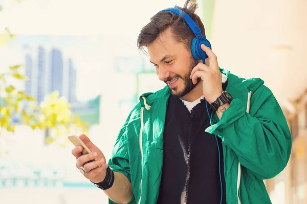 Hombre Hipster Guapo Con Auriculares Azules Escuchando Música Navegando Teléfono — Foto de Stock