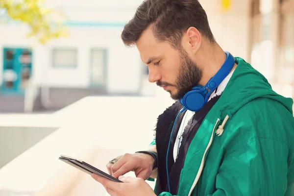 Volwassen Stijlvolle Man Met Blauwe Hoofdtelefoon Surfen Tablet Permanent Buiten — Stockfoto