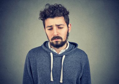 Gri duvar arka plan üzerinde izole hiçbir enerji motivasyon depresif hayat bir üzgün adam arayan yalnız genç portresi vardır