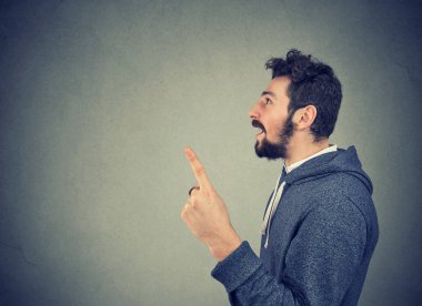 Casual adam gri arka plan üzerinde parlak fikir sahip olmak kadar parmak tutan hoodie yan görünüm