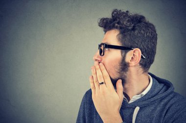 Genç adam ise dedikodu ve sırları fısıltıyla söylüyorum ağız kapsayan. 