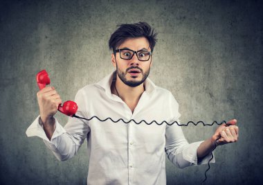 Bir cep telefonu üzerinde şok edici haber alma ve korku ile kameraya bakarak adam