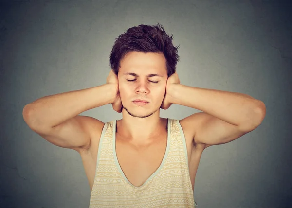 Young Man Covering Ears Keeping Eyes Closed Avoiding Noise Gray — Stock Photo, Image