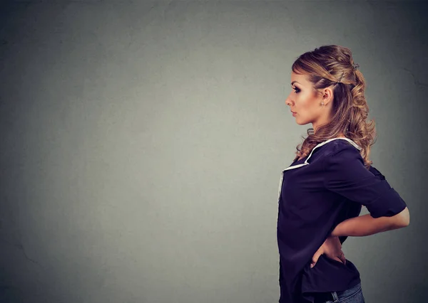 灰色の背景の上にエレガントな服立っての現代の若い女性の側面図 — ストック写真