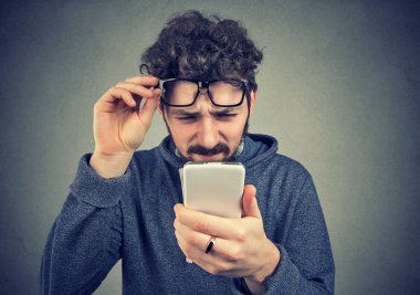 Having üzmek cep telefonu görme gözlük takan bir adam portresi closeup görme sorunları vardır. Kafa karıştırıcı teknoloji