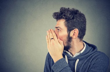 Genç adam ise dedikodu ve sırları fısıltıyla söylüyorum ağız kapsayan. 