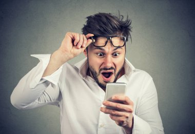Beyaz gömlek ve gözlük smartphone çıkıyor şok içinde izlerken yetişkin iş adamı