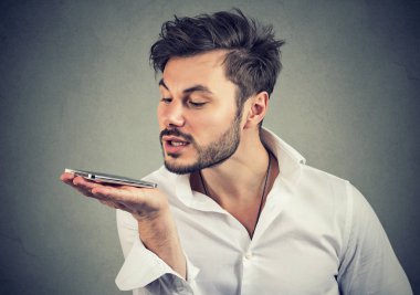Duvar arka plan üzerinde izole bir akıllı telefon ses tanıma işlevi kullanılarak hipster adam