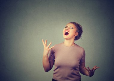 Tıknaz kadın gri arka plan üzerinde büyük histeri yüksek sesle bağırarak
