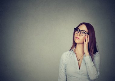 Kafa dokunmaktan ve gri arka plan üzerine kararı tefekkür ararken genç güzel esmer kadın