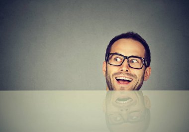 Masa altından bakmak ve uzak gri arka plan üzerinde seyir bardaklarda yetişkin çılgın adam