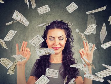 Happy business woman meditating under money rain clipart