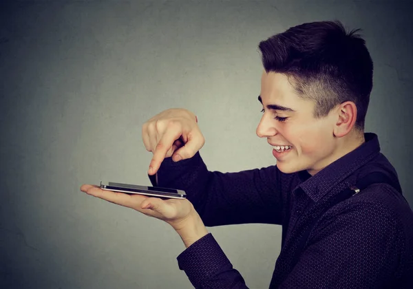Vista Lateral Jovem Homem Feliz Usando Smartphone Sorrindo Fundo Cinza — Fotografia de Stock
