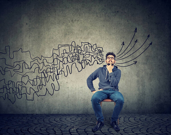 человек, смотрящий вверх и собирающий воедино свои мысли, планируя сделать выводы на фоне стены
