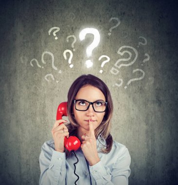 Yanlış anlama ve uzak çağrı. Bir telefonda konuşurken karışık endişeli kadın gri arka plan üzerinde izole birçok soru vardır.