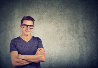 Gözlük takan ve gri arka plan üzerinde akıllı arıyorum geçti silah ile genç casual adam