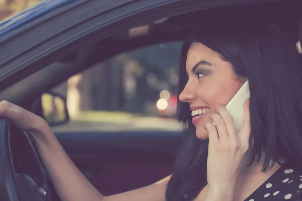 元気よく車を運転している間携帯電話で話すブルネットの側面図 — ストック写真