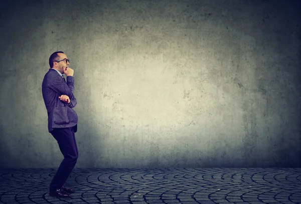 Korku ayakta uzağa arıyorsunuz endişeyle gri arka plan üzerinde endişeli işadamı yan görünüm