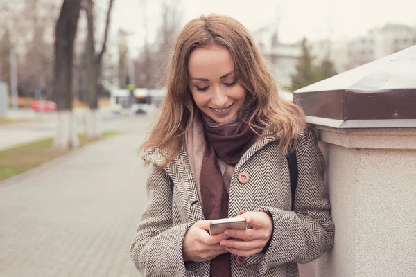 Młoda Brunetka Płaszcz Pomocą Smartphone Stojąc Ulicy Uśmiecha Się Radośnie — Zdjęcie stockowe