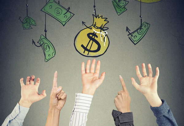Many hands in the air trying to reach money bag hanging on the hooks. Financial concept
