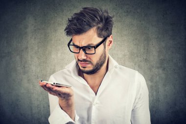 Ses komutu görev ile üzgün olmanın smartphone tutan tişörtlü adam Genç sakallı